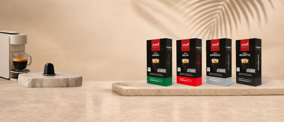 Mood Espresso Lungo, Decaf, Espresso and Ristretto capsule boxes beside a coffee machine